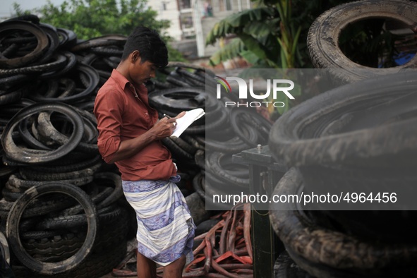 Workers seen handling pieces of old tyres to be recycled in Dhaka,  Bangladesh on 07 October 2019. 