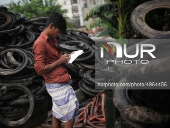 Workers seen handling pieces of old tyres to be recycled in Dhaka,  Bangladesh on 07 October 2019. (