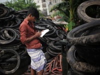 Workers seen handling pieces of old tyres to be recycled in Dhaka,  Bangladesh on 07 October 2019. (