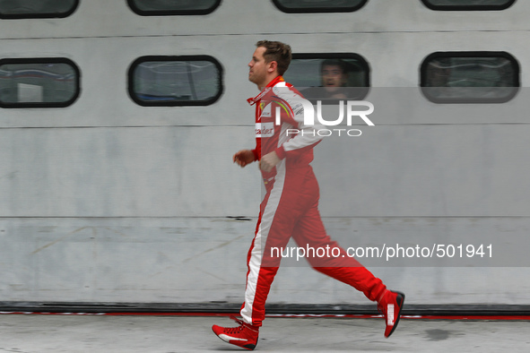 German F1 driver Sebastian Vettel of  of Scuderia Ferrari runs to his garage ahead of Malaysian Formula One Grand Prix at Sepang Internation...
