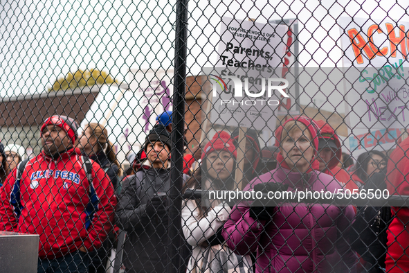 Striking teachers and supporters look on an as they are initially closed out of rallying at a soccer field at the Lincoln Yards development...