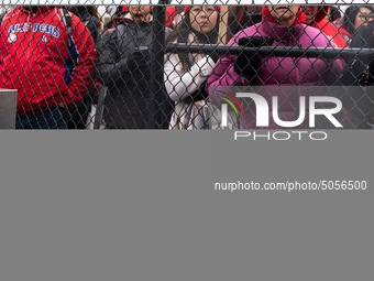 Striking teachers and supporters look on an as they are initially closed out of rallying at a soccer field at the Lincoln Yards development...