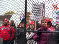 Striking teachers and supporters look on an as they are initially closed out of rallying at a soccer field at the Lincoln Yards development...