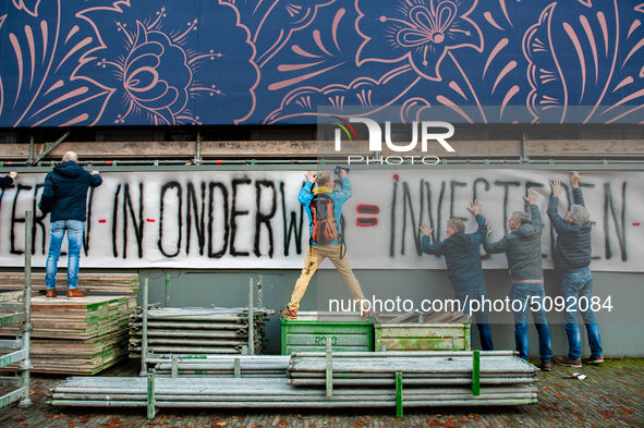 A group of teachers are seen holding a very big banner on a wall during the massive teachers demonstration that took place in The Hague, on...