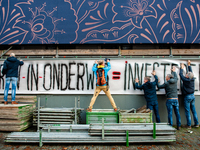 A group of teachers are seen holding a very big banner on a wall during the massive teachers demonstration that took place in The Hague, on...