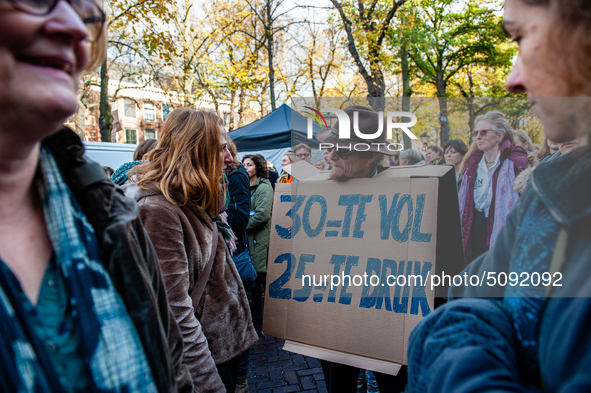 A man is seen wearing a placard while speaking with a woman during the massive teachers demonstration that took place in The Hague, on Novem...