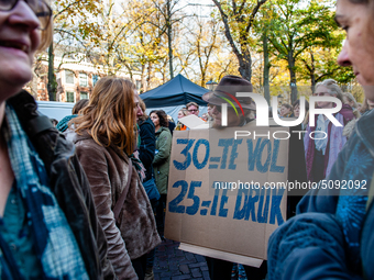 A man is seen wearing a placard while speaking with a woman during the massive teachers demonstration that took place in The Hague, on Novem...