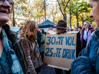 A man is seen wearing a placard while speaking with a woman during the massive teachers demonstration that took place in The Hague, on Novem...