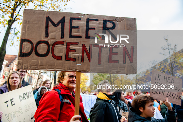 A woman is seen holding a big placard that means more teachers, during the massive teachers demonstration that took place in The Hague, on N...