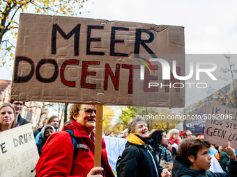 A woman is seen holding a big placard that means more teachers, during the massive teachers demonstration that took place in The Hague, on N...