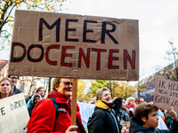 A woman is seen holding a big placard that means more teachers, during the massive teachers demonstration that took place in The Hague, on N...