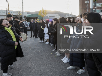 Nov 14, 2019 - Sangju, South Korea-A Group of High Schoolers cheer up for their senior group at entrance gate of Sangju high school in Sangj...