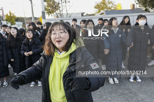 Nov 14, 2019 - Sangju, South Korea-A Group of High Schoolers cheer up for their senior group at entrance gate of Sangju high school in Sangj...