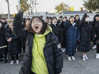 Nov 14, 2019 - Sangju, South Korea-A Group of High Schoolers cheer up for their senior group at entrance gate of Sangju high school in Sangj...