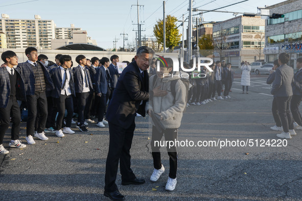 Nov 14, 2019 - Sangju, South Korea-A Group of High Schoolers cheer up for their senior group at entrance gate of Sangju high school in Sangj...