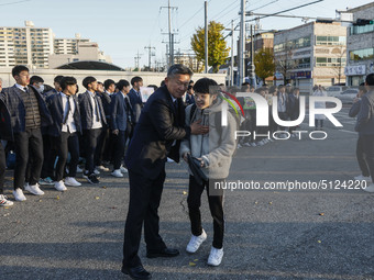 Nov 14, 2019 - Sangju, South Korea-A Group of High Schoolers cheer up for their senior group at entrance gate of Sangju high school in Sangj...