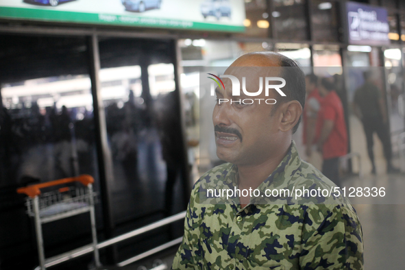 Nurul Islam seen reacting while talking with journalists as he waits to receive his wife Sumi Akter at Hazrat Shahjalal International Airpor...