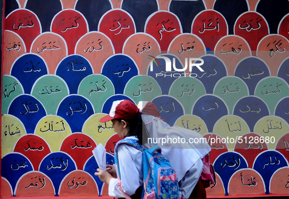 Children with Parents see education Graffiti themed walls in a narrow alley in Pademangan, Jakarta, November, 15,2019. Graffiti on the wall...