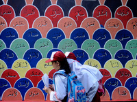 Children with Parents see education Graffiti themed walls in a narrow alley in Pademangan, Jakarta, November, 15,2019. Graffiti on the wall...