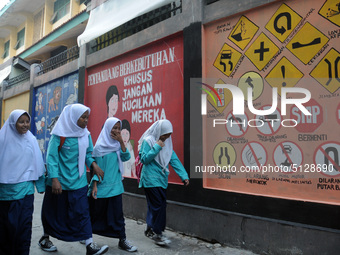 Children with Parents see education Graffiti themed walls in a narrow alley in Pademangan, Jakarta, November, 15,2019. Graffiti on the wall...