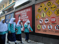 Children with Parents see education Graffiti themed walls in a narrow alley in Pademangan, Jakarta, November, 15,2019. Graffiti on the wall...