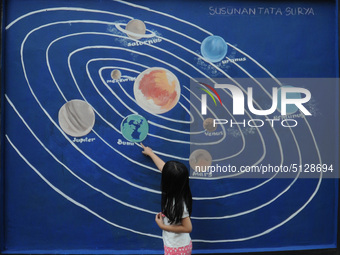 Children with Parents see education Graffiti themed walls in a narrow alley in Pademangan, Jakarta, November, 15,2019. Graffiti on the wall...