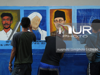 Children with Parents see education Graffiti themed walls in a narrow alley in Pademangan, Jakarta, November, 15,2019. Graffiti on the wall...