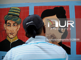 Children with Parents see education Graffiti themed walls in a narrow alley in Pademangan, Jakarta, November, 15,2019. Graffiti on the wall...