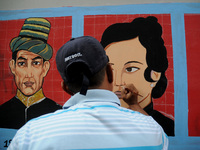 Children with Parents see education Graffiti themed walls in a narrow alley in Pademangan, Jakarta, November, 15,2019. Graffiti on the wall...