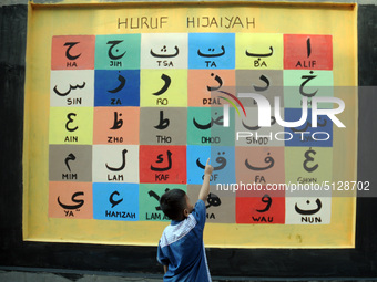 Children with Parents see education Graffiti themed walls in a narrow alley in Pademangan, Jakarta, November, 15,2019. Graffiti on the wall...