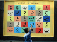 Children with Parents see education Graffiti themed walls in a narrow alley in Pademangan, Jakarta, November, 15,2019. Graffiti on the wall...