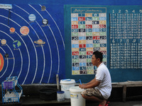 Children with Parents see education Graffiti themed walls in a narrow alley in Pademangan, Jakarta, November, 15,2019. Graffiti on the wall...