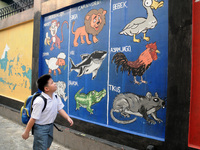 Children with Parents see education Graffiti themed walls in a narrow alley in Pademangan, Jakarta, November, 15,2019. Graffiti on the wall...