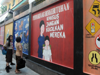 Children with Parents see education Graffiti themed walls in a narrow alley in Pademangan, Jakarta, November, 15,2019. Graffiti on the wall...