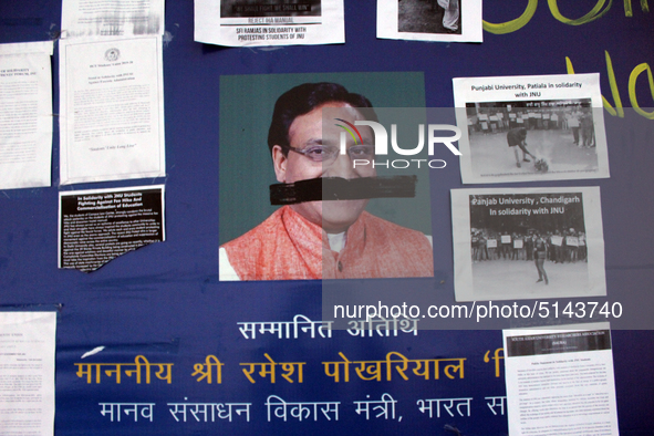 A defaced poster of Union Minister of Human Resource Development Ramesh Pokhriyal is seen as students protest against the hostel fee hike, a...