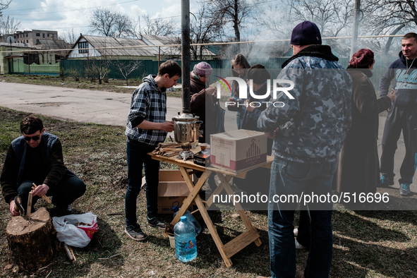 Young man on the left, volunteer at the local protestant church,  making free tea for the population. It is still very cold in the morning i...