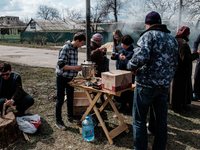 Young man on the left, volunteer at the local protestant church,  making free tea for the population. It is still very cold in the morning i...