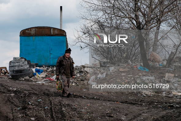 Man walking out of the city dump. On April 6 2015, we visit Krasnogorovka. What we saw is the evident beginning of a serious humanitarian cr...