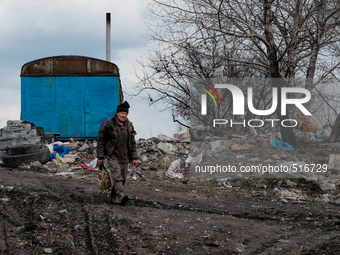 Man walking out of the city dump. On April 6 2015, we visit Krasnogorovka. What we saw is the evident beginning of a serious humanitarian cr...