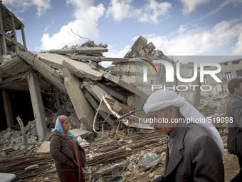Syrian Kurdish refugees walk past destroyed buildings upon their arrival in Kobane, Syria, April 3, 2015. Some Syrian refugees who fled to T...