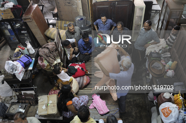 Ayub Mallik (M) who has been working at the Russell Exchange for more than 25 years showing old clothes to the buyers during the old clothes...