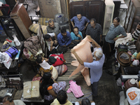 Ayub Mallik (M) who has been working at the Russell Exchange for more than 25 years showing old clothes to the buyers during the old clothes...