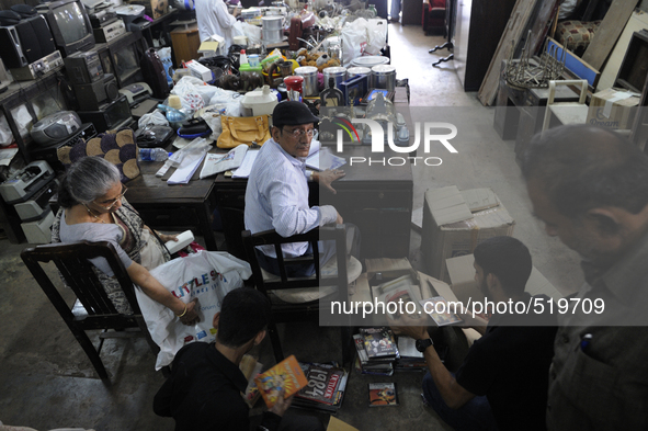 Md Omar oversees a seller who came in to put up their stuff  for auction during the old clothes auction at The Russell Exchange on thursday...