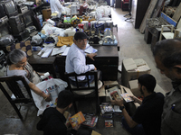 Md Omar oversees a seller who came in to put up their stuff  for auction during the old clothes auction at The Russell Exchange on thursday...