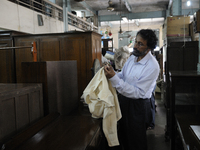 A customer seeing the button of a old shirt that he just bought during the old clothes auction at The Russell Exchange on thursday 2nd April...