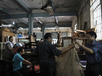 Saugata Roy the cashier of The Russell Exchange helping customers to fold a "sari" during the old clothes auction at The Russell Exchange on...