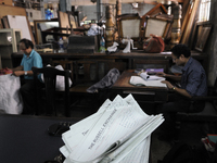 Log papers of The Russell Exchange lie on the table while on the back Saugata Roy the cashier of The Russell Exchange gets busy with his wor...