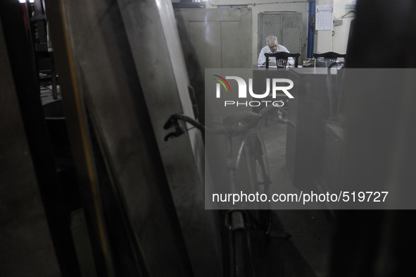 Reflection of Arshad  Saleem  on a mirror while he is preparing for the sunday auction during the old clothes auction at The Russell Exchang...