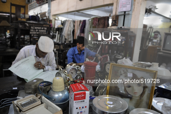 Md Omar(L) and Azharuddin(R) a young recent recruit busy at busy entering information on the log book for next day's auction at The Russell...