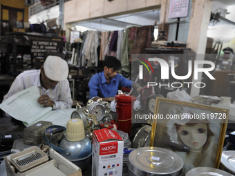 Md Omar(L) and Azharuddin(R) a young recent recruit busy at busy entering information on the log book for next day's auction at The Russell...